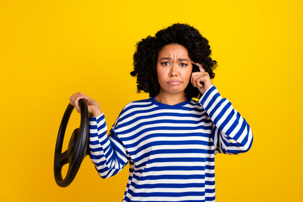 Portrait of ecstatic girl with afro hairstyle hold steering wheel scream yeah win new car in lottery isolated on yellow color background.图片下载