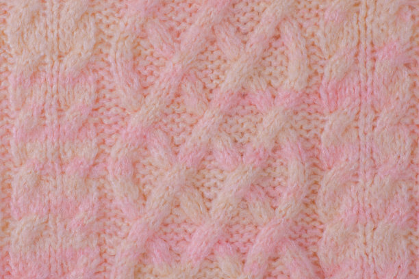 粉红色和米色的细节针织项目。毛巾织物的质感作为微距照片的背景。图片下载