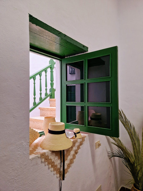 老式加那利农舍天井内院窗台上的传统兰萨罗特草帽——传统白色与绿色的田园、乡村形象图片下载
