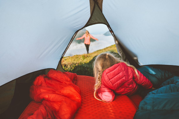 孩子在露营帐篷里看着妈妈家庭旅行度假冒险生活方式孩子徒步旅行与父母生态旅游户外装备在山上图片下载