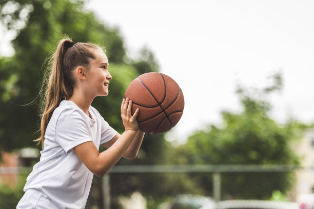 一个小女孩在公园里打篮球的照片图片下载