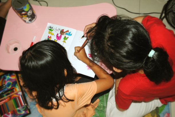 两个孩子正在画一幅艺术品。图片下载