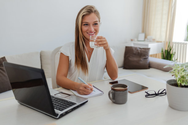 一个迷人的年轻女商人在她的家庭办公室工作时在她的笔记本上写字的剪辑照片。图片下载