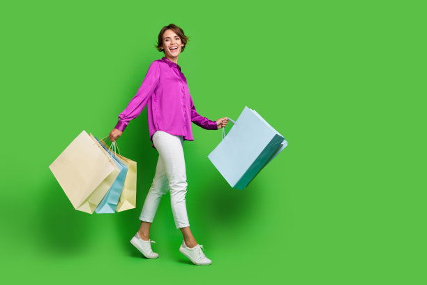 穿着时髦衣服的无忧无虑的积极女孩的全身照片，在绿色背景上孤立的商场空间图片下载