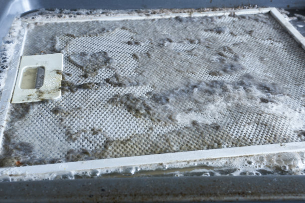 清洗引擎盖过滤网。厨房油烟机过滤器在清洁溶液中被弄脏图片下载
