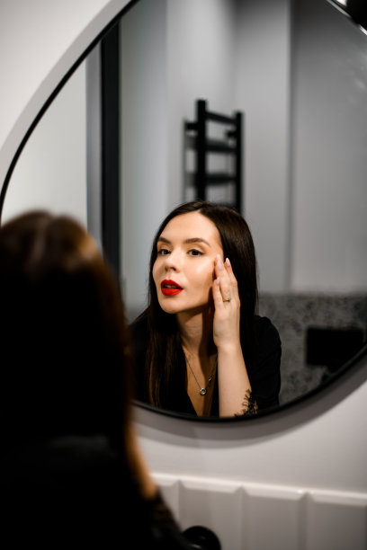 一个漂亮的黑女人在大镜子前画她的眼睛图片下载