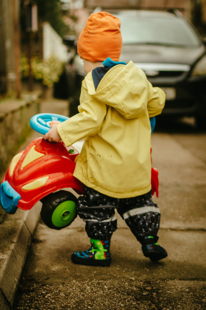 小男孩在雨中玩耍的照片图片下载