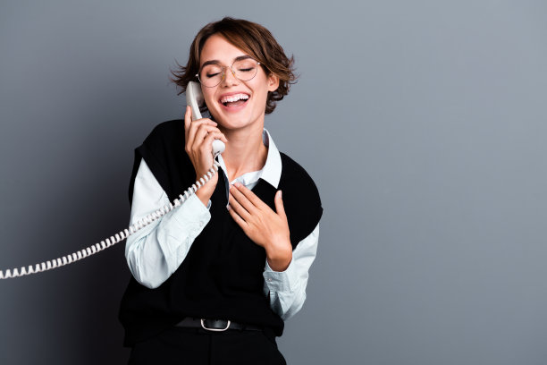 照片的积极欢乐的女办公室秘书在时髦的衣服说话笑空空间孤立的灰色背景图片下载