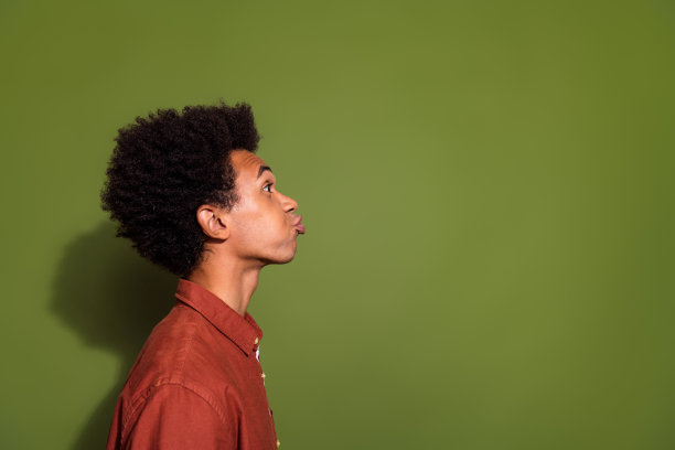 照片肖像漂亮的年轻男性侧面兴奋的亲吻空穿时髦的棕色服装孤立在卡其色的背景图片下载