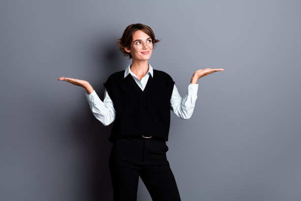 照片中甜美梦幻的女投资人戴着黑色马甲眼镜，手臂上的鳞片看起来空荡荡的，孤立的灰色背景图片下载