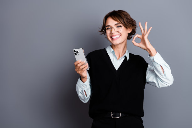 快乐快乐的女人穿着时髦的黑色衣服的照片，好的标志，质量好，干得好，空白的空间孤立在灰色的背景上图片下载