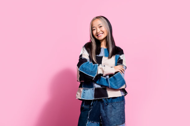 可爱开朗的泰国人的照片，露齿微笑，双臂交叉，在粉红色的背景上摆出孤立的姿势图片下载