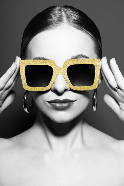 女性肖像与经典发型和金色复古太阳镜在灰色背景图片下载