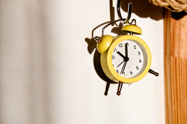 黄色的小石英闹钟挂在墙上图片下载