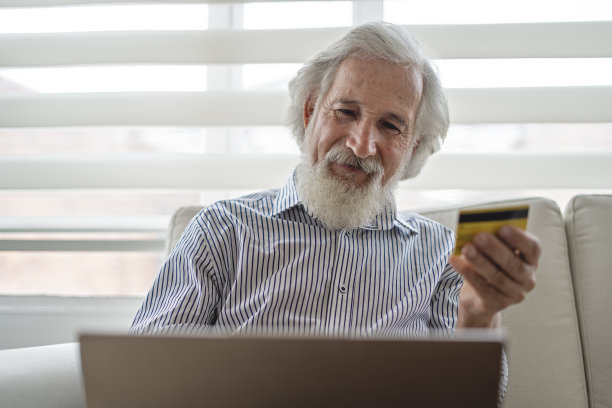 一个老人在家里用信用卡网购的照片。图片下载