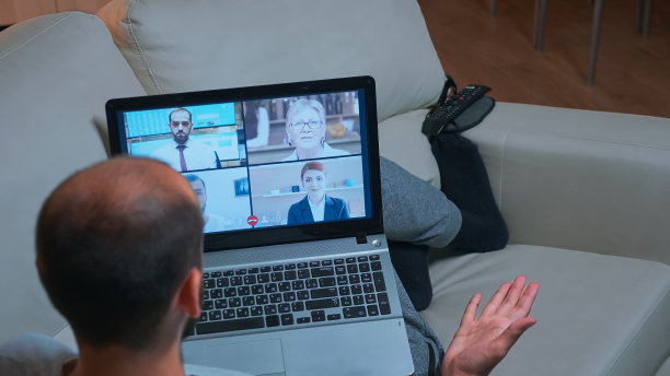 疲惫的男子躺在沙发上与队友聊天的背影图片下载