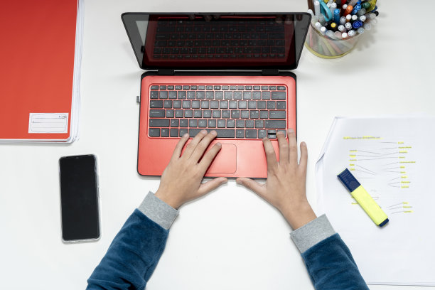 俯拍照片，捕捉到一个青春期前的孩子熟练地在笔记本电脑上打字图片下载