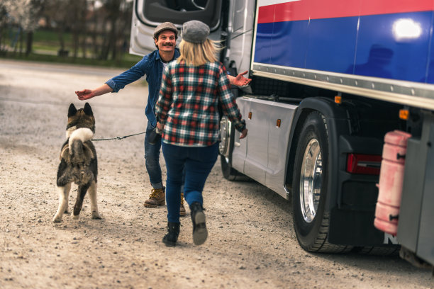 一对卡车司机夫妇在旅途中休息一下，和他们的狗一起玩图片下载