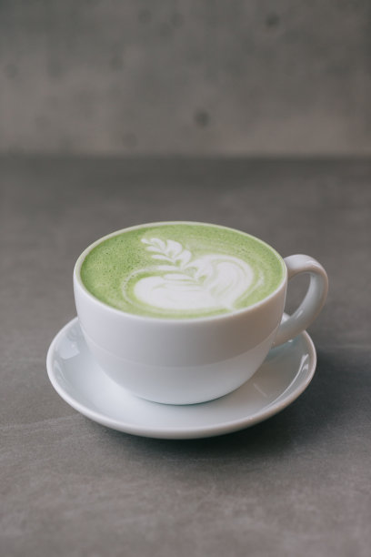 一杯抹茶在灰色的石头背景上。关闭了。图片下载