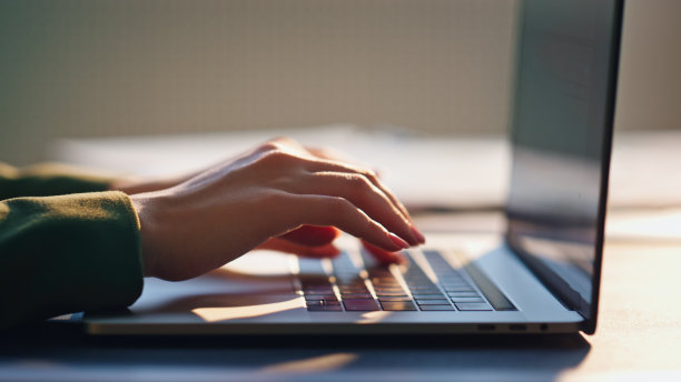 女人的手打字键盘笔记本电脑近。女孩自由职业者在笔记本上工作图片下载