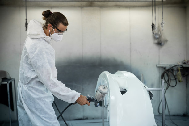 汽车服务人员在防护罩涂装车身。Oxus图片下载