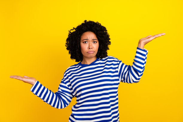 照片中，心烦意乱的迷人女孩穿着时髦的衣服展示对比产品，空白的空间孤立在黄色的背景上图片下载