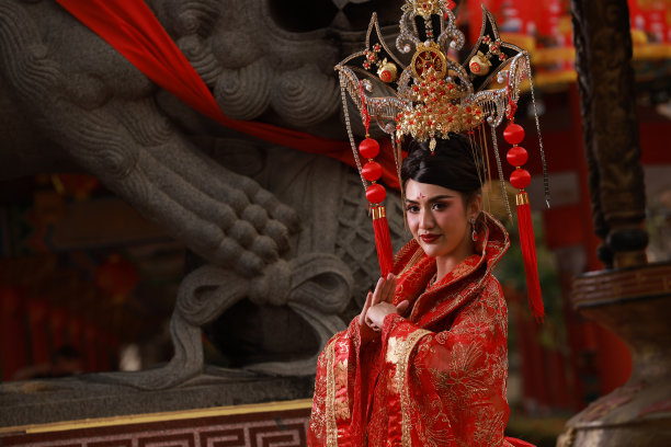 身着红色传统旗袍的亚洲妇女手持香火，向佛陀或祖先祈祷图片下载