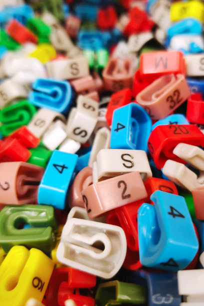 衣架尺寸标记，颜色编码服装尺寸彩色塑料标签项目，适用于服装店。零售服装购物概念。时尚主题背景与复制空间。图片下载