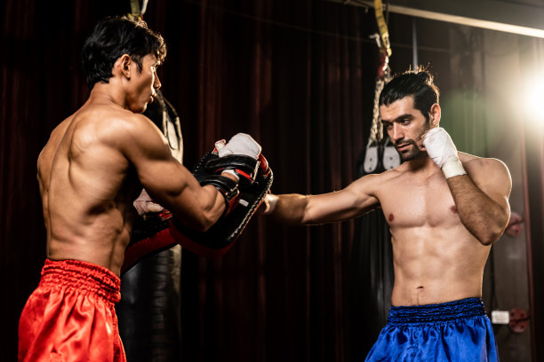 亚洲和高加索拳师在训练中释放出拳。动力图片下载