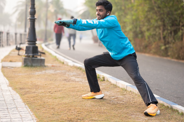 一个年轻人在跑步前伸展的照片图片下载