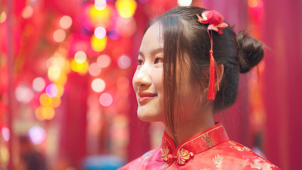 年轻，红发亚洲女孩旗袍肖像微笑在中国寺庙装饰灯笼。祝你新年吉祥快乐。图片下载