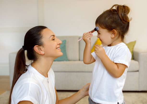 小女孩在家里用化妆刷，和妈妈玩得很开心图片下载