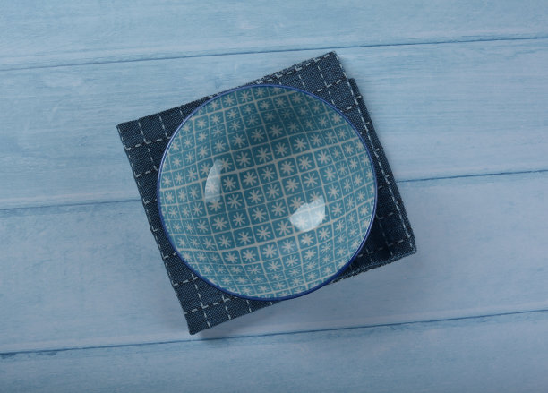 传统高档餐具日本陶瓷瓷蓝色艺术画樱花图案圆形大小光泽盘碗布和筷子在蓝色的木桌背景图片下载