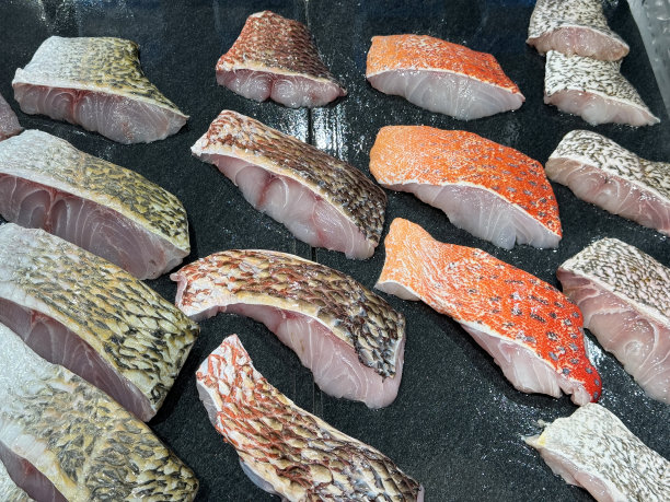 新鲜海鲜的特写图像，红石斑鱼，海鲈鱼和红鲷鱼排在冷冻金属托盘上保持新鲜，冷藏鱼贩展示，高架视图，重点放在前景图片下载