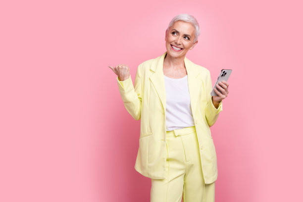 成功的女商人的照片，西装，手指空白的空间，使用智能手机应用程序规划孤立的粉红色背景图片下载