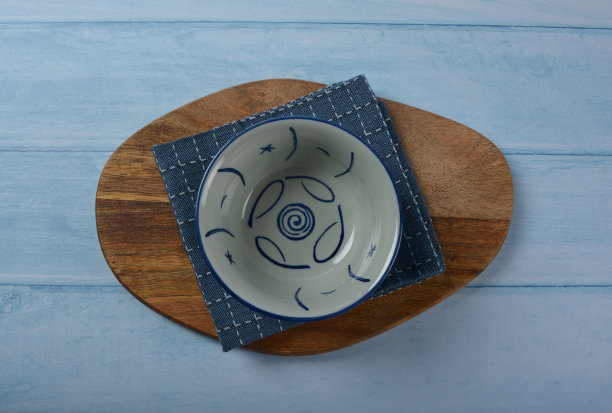 传统高档餐具日本陶瓷瓷蓝色艺术画樱花图案圆形大小光泽盘碗布和筷子在蓝色的木桌背景图片下载