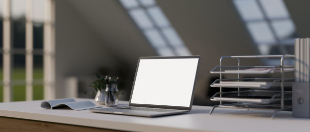 一个现代化的办公桌工作空间，配有白屏笔记本电脑模型和办公用品。图片下载