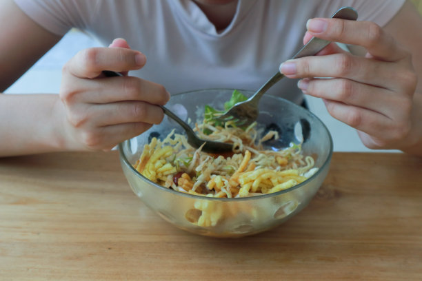 一个女人吃蔬菜沙拉的裁剪照片图片下载