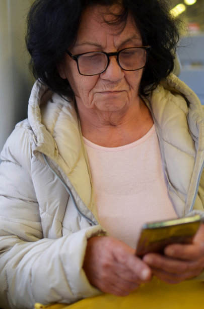 一位老妇人在火车上使用手机的照片图片下载