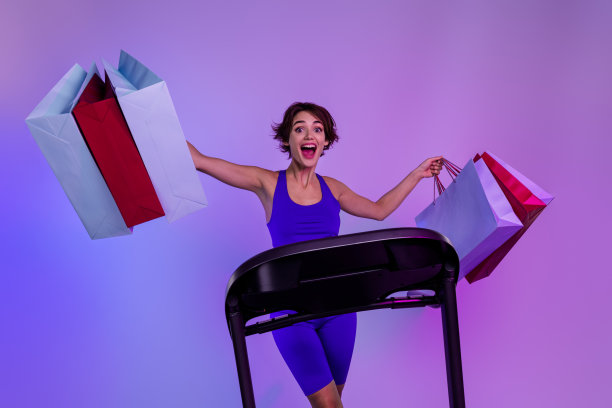 兴奋的运动女士跑步机的照片提高购物包购买在运动中心特别优惠隔离紫外线彩色背景图片下载