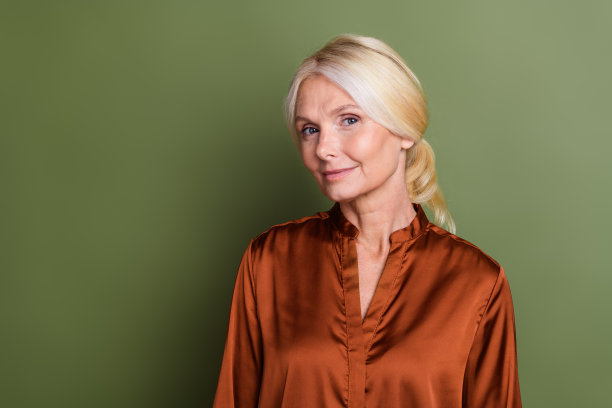 照片肖像可爱的资深女士迷人的微笑模型推广穿着时尚的丝绸棕色服装孤立的卡其色背景图片下载