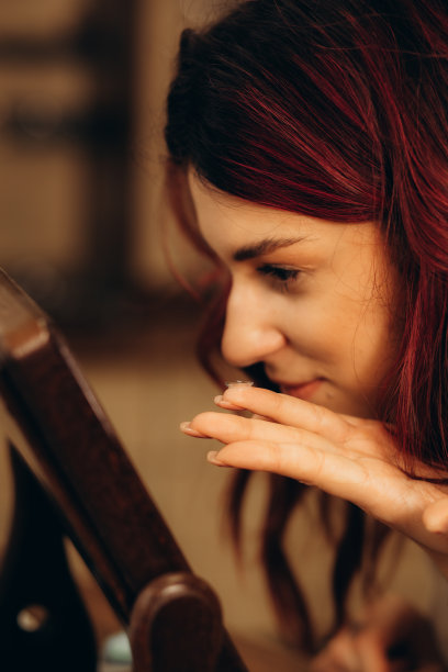 女孩在镜子里试隐形眼镜。兴奋的女人第一次尝试隐形眼镜图片下载