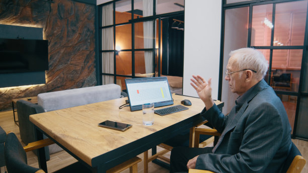 高级商人和坐在家里办公室里的人讨论桌子上的数据图片下载