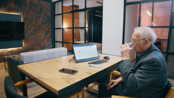 老商人吃完药坐在家里办公室喝水图片下载