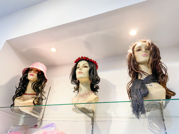 戴着假发和夏帽的女性人体模型。一家服装商店在购物中心的展示。图片下载