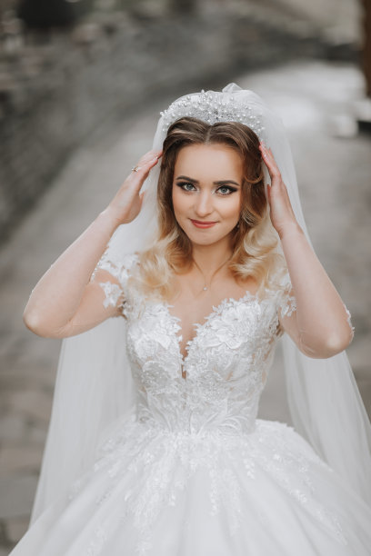 幸福的年轻女子新娘，长卷发，白色礼服，微笑，户外照片。图片下载