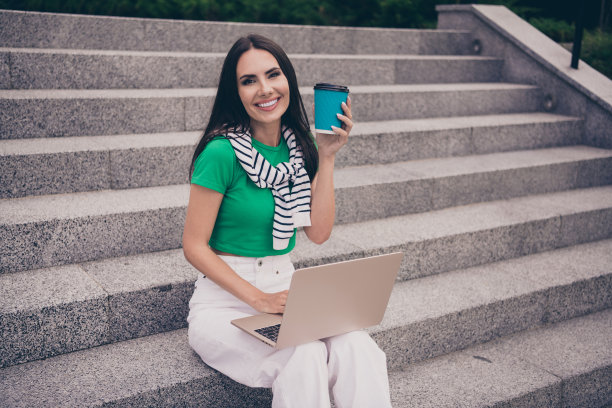 照片中，一名穿着夏装的女子坐在楼梯上，在户外用上网本喝拿铁图片下载