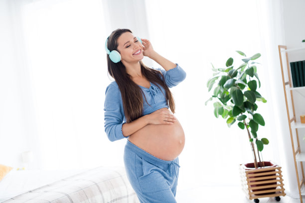 照片开朗可爱可爱的怀孕女孩未来的妈妈触摸大肚子享受怀孕期间灯光室室内室内图片下载
