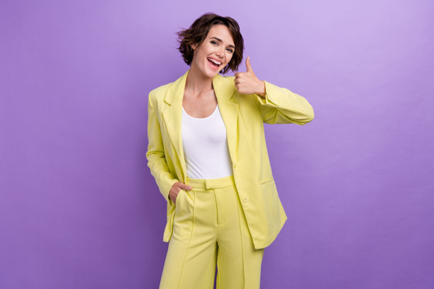 年轻的商务女士的照片大拇指好的工作反馈穿时髦优雅的魅力石灰黄色西装孤立在紫色的背景图片下载