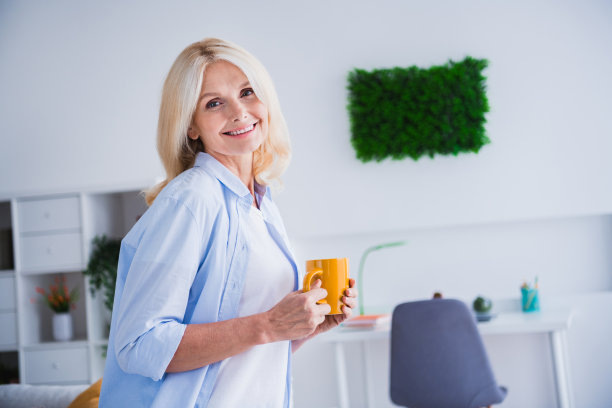 可爱的高级女士的照片肖像拿着咖啡杯工作暂停放松房子室内设计舒适的客厅现代家居装饰图片下载